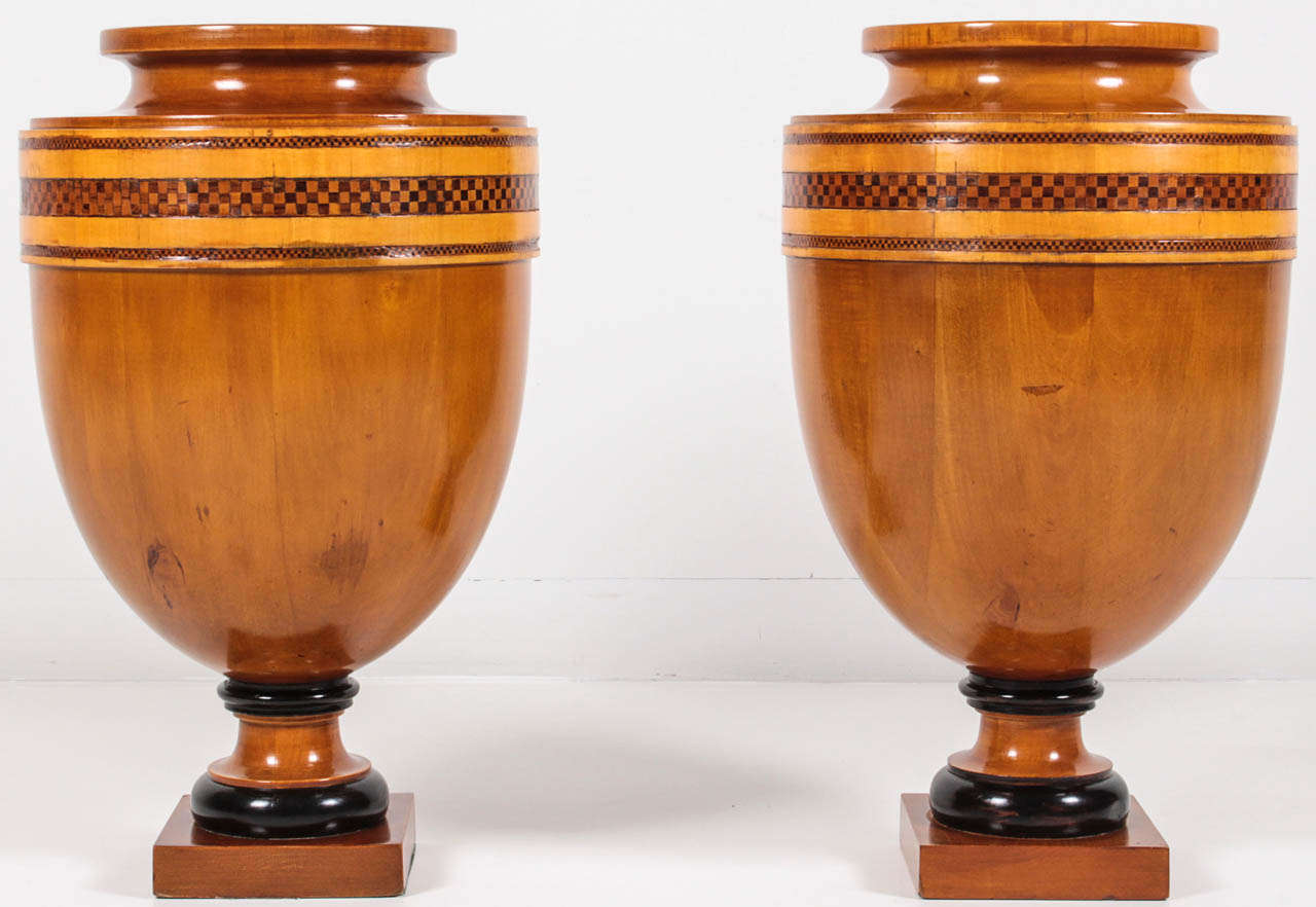 A pair of Continental fruitwood, inlaid and ebonized urns, Early 20th Century, of classical form.